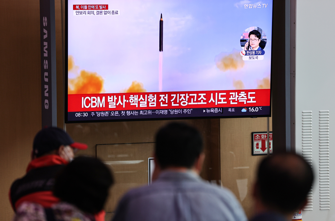 Passersby watch a TV report of North Korea`s missile launch at Seoul Station on Thursday. (Yonhap)