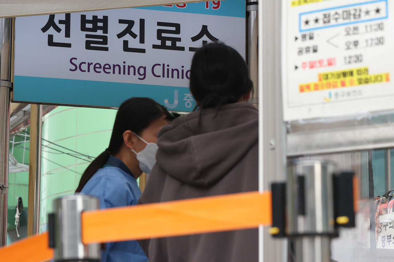 A medical worker guides a citizen at a makeshift testing center in Seoul last Thursday. (Yonhap)