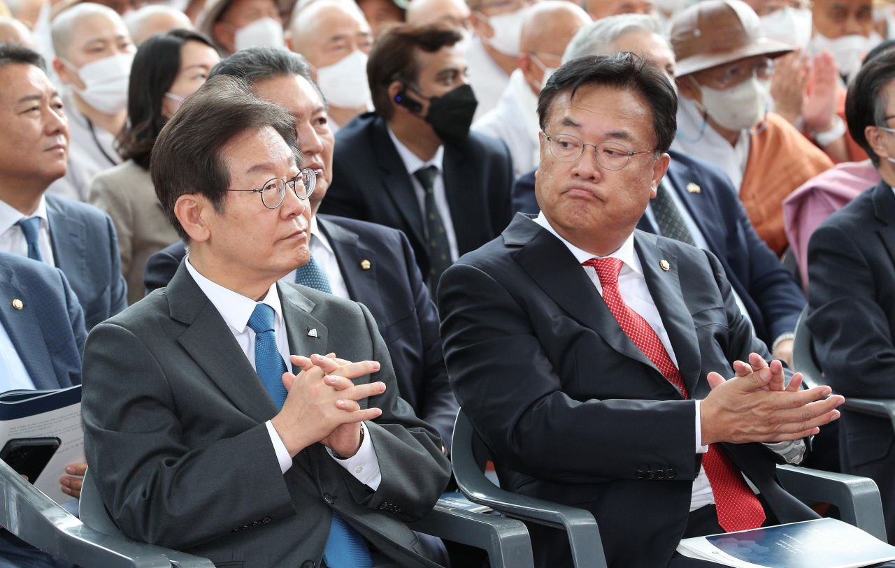 This file photo from last Wednesday, shows Rep. Lee Jae-myung (L), chairman of the main opposition Democratic Party, and Rep. Chung Jin-suk, interim chief of the ruling People Power Party, attending the inauguration ceremony of Ven. Jinwoo, new executive chief of the Jogye Order at Jogye Temple in Seoul. (Yonhap)