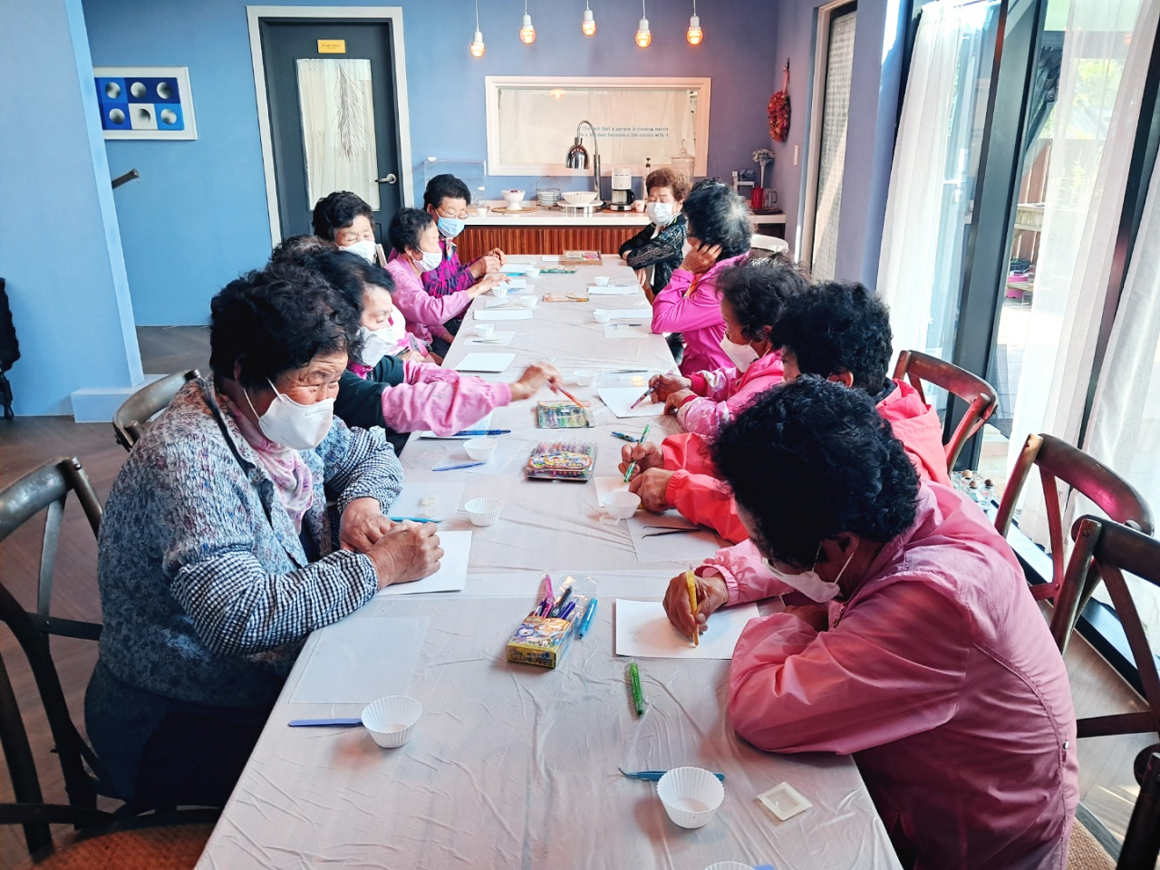 Sinpung grandmothers start drawing with the theme of the fall season during an art class on Sept. 28. (Lee Si-jin/The Korea Herald)