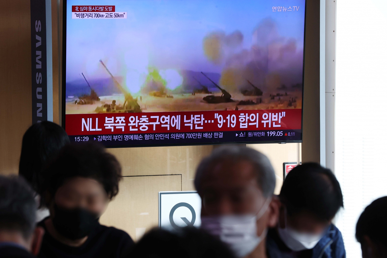 Passersby watch a TV report of North Korea`s missile launch at Seoul Station. (Yonhap)