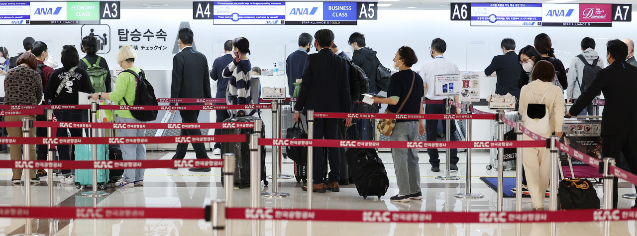 Passengers check in for a Gimpo-Haneda flight at the international flight counter at Gimpo International Airport in Gangseo-gu, Seoul, on Friday morning, one day before the first weekend after Japan allowed Koreans to travel without a visa. (Yonhap)