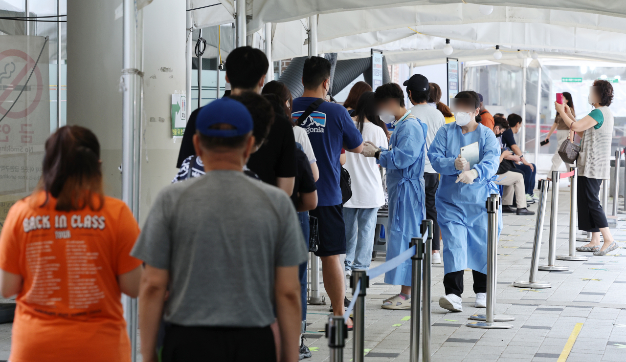 People wait in line for COVID-19 tests at a local testing station in Mapo-gu, Seoul on August 5. (Yonhap)