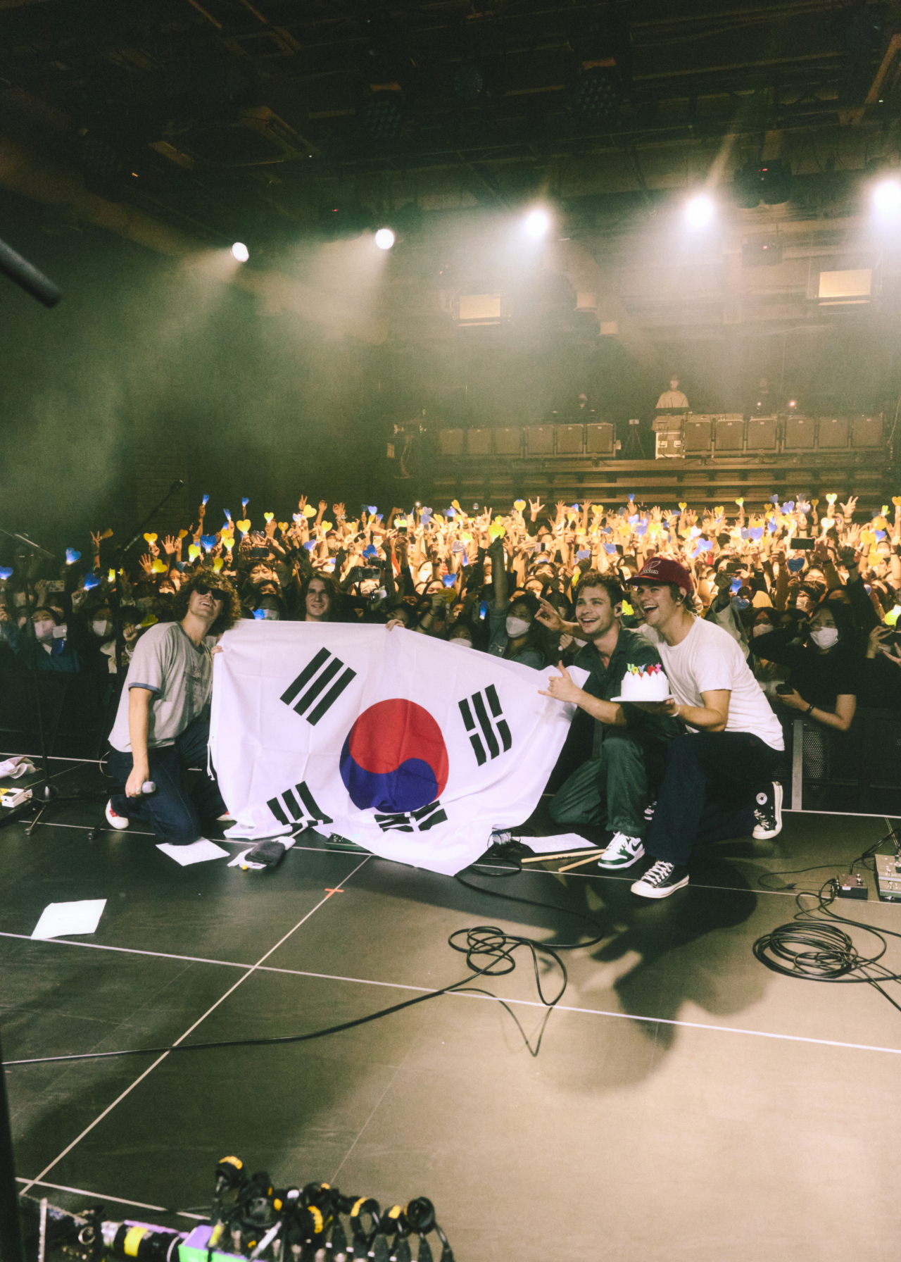 American alt-pop band almost monday takes photos with concertgoers while holding Taegeukgi, the flag of Korea, after its first live concert in Korea. The band held a concert at Watcha Hall in Mapo-gu, in western Seoul, on Friday. (Universal Music Korea)