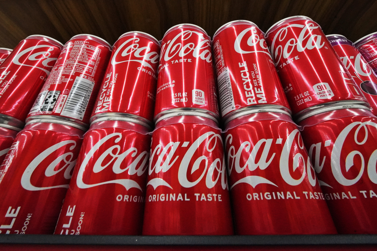 This file photo shows cans of Coca-Cola on display at a grocery market in Uniontown, Pa., April 24, 2022. The soft drink giant's sponsorship of the flagship UN climate conference, known as COP27, sparked an online backlash and highlighted broader concerns about corporate lobbying and influence. (AP-Yonhap)