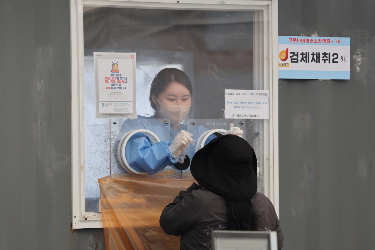 A person is tested for COVID-19 at a testing center in Seoul on Sunday. (Yonhap)