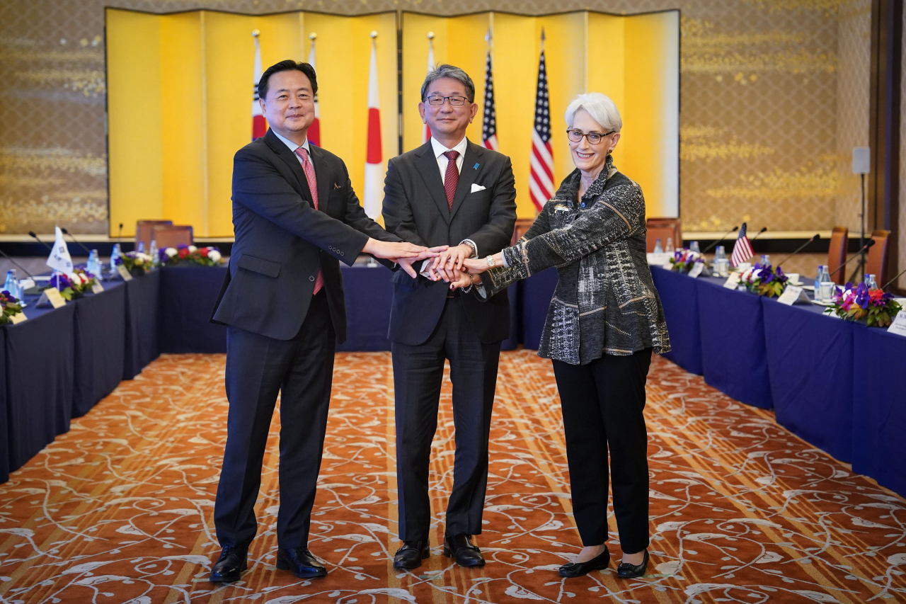 South Korean Vice Foreign Minister Cho Hyun-dong (left), Japanese Vice Foreign Minister Takeo Mori (center) and US Deputy Secretary of State Wendy Sherman hold hands during a media conference after their trilateral consultation meeting in Tokyo on Wednesday. (South Korea's Ministry of Foreign Affairs)