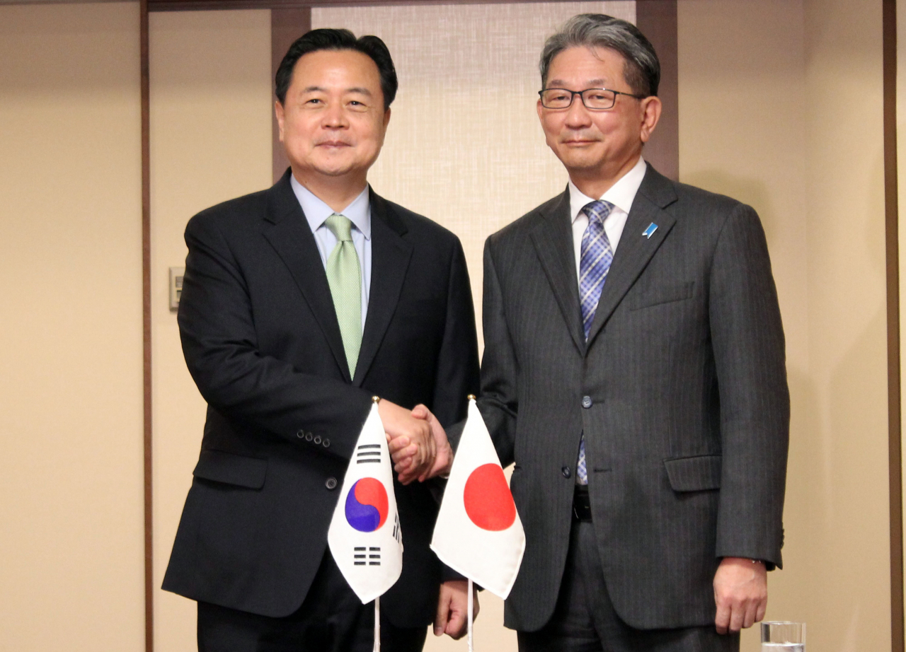 Seoul's First Vice Foreign Minister Cho Hyun-dong (left) shakes hands with his Japanese counterpart Takeo Mori during their bilateral meeting in Tokyo on Tuesday. (Yonhap)