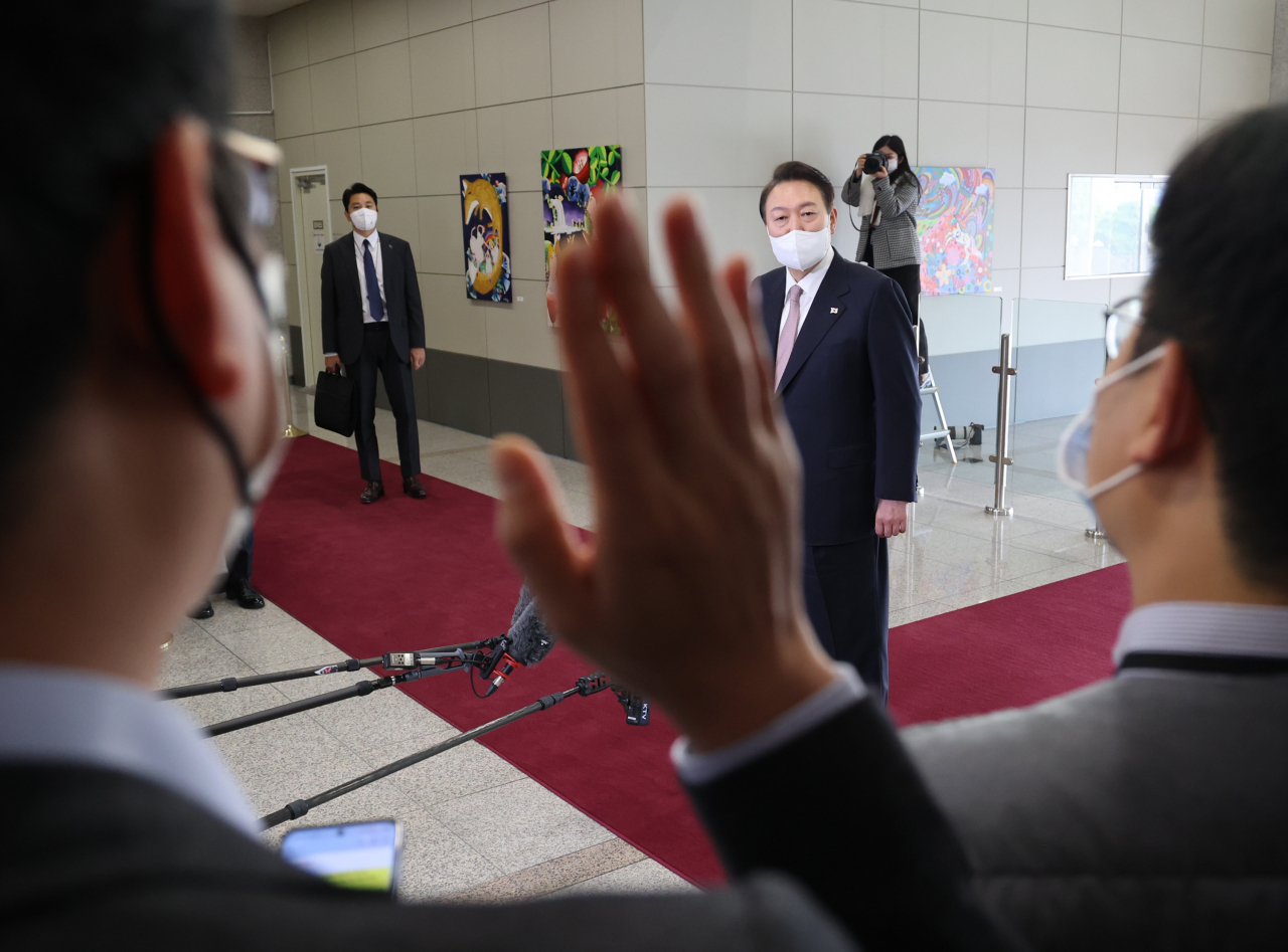 President Yoon Suk-yeol takes questions from reporters as he arrives at the presidential office in Seoul on Friday. (Yonhap)