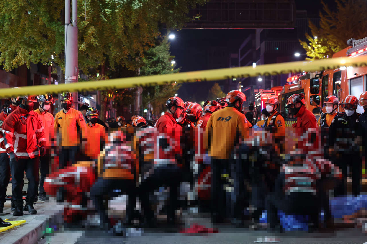 Rescue workers respond to the tragic accident after at least 153 people were killed in a deathly stampede during Halloween parties overnight. (Yonhap)
