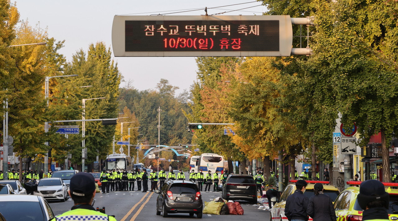 A notice of the cancellation of the Walking Festival on Jamsu Bridge is shown on an electronic street board in Itaewon, where police are investigating, Sunday. (Yonhap)