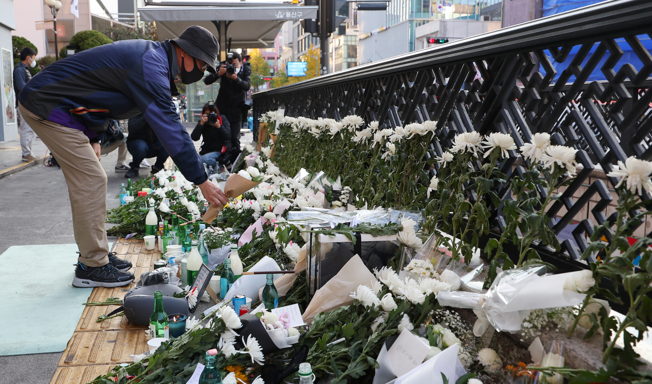 A mourner lays flowers near an exit of Itaewon Subway Station on Monday morning. (Yonhap)