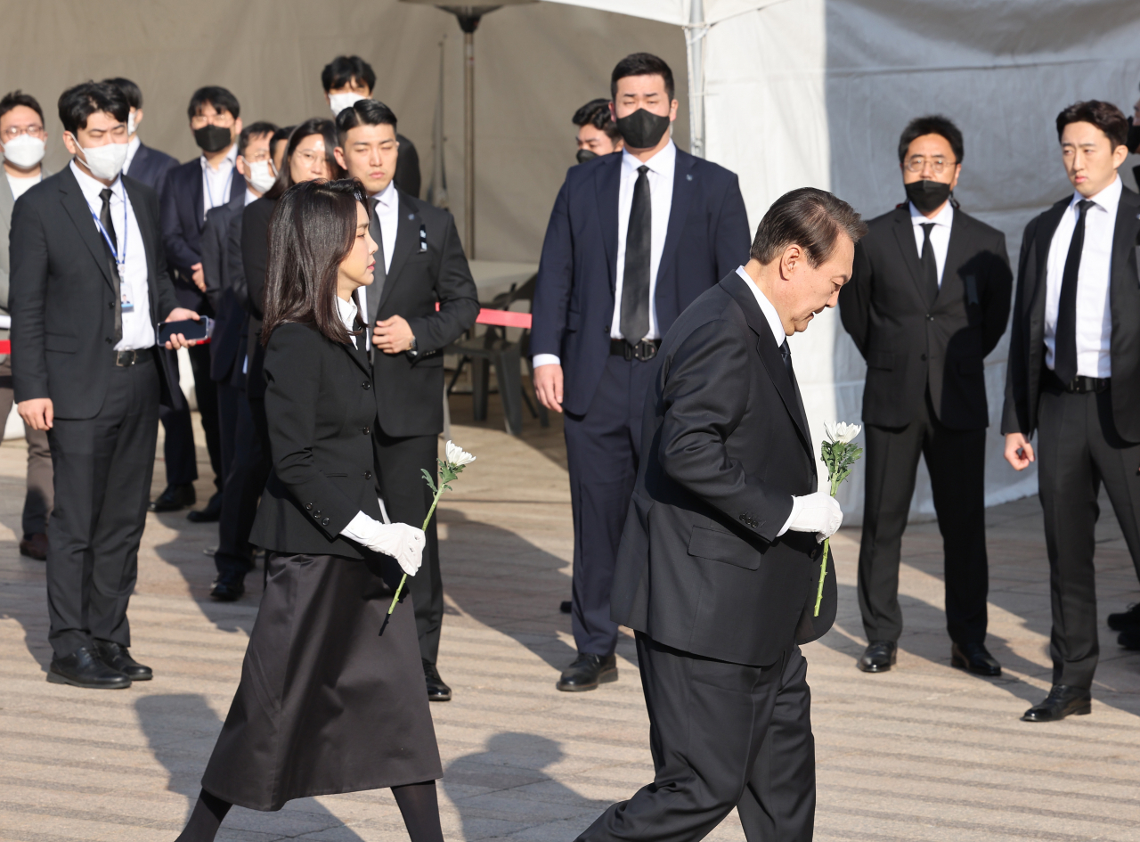 President Yoon Suk-yeol (right) and first lady Kim Keon-hee visit a mourning altar for the Itaewon disaster victims set up in the front of Seoul City Hall on Monday morning. (Yonhap)