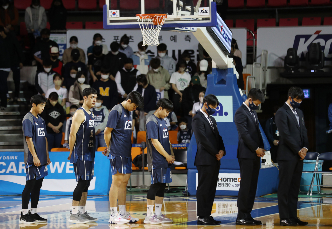 Players and coaching staff of Jeonju KCC Egis bow their heads as a show of respect to the victims of the deadly crowd surge in Itaewon before the KBL game against Seoul SK Knights in Jeonju, South Jeolla Province, Monday. (Yonhap)