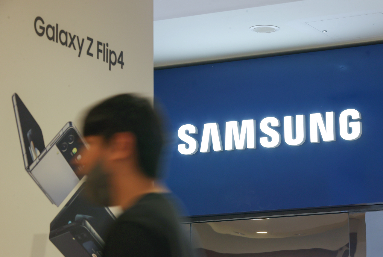 A passenger walks past the Samsung logo in the company's Seoul office. (Yonhap)