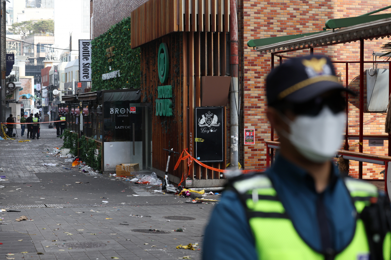 A police officer stands on the street behind Hamilton Hotel in Itaewon on Tuesday where the deadly crowd crush occurred on Saturday night. (Yonhap)