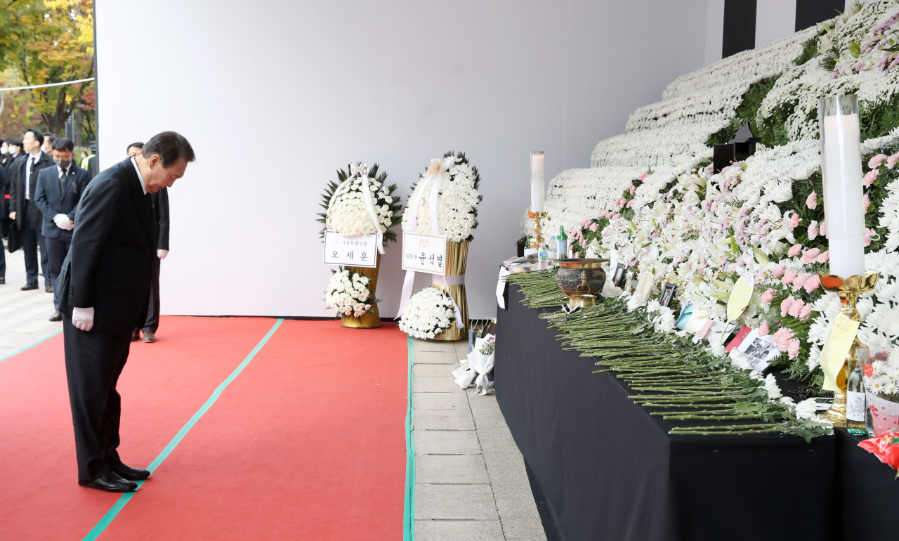President Yoon Suk-yeol bows his head in silent tribute to the victims of the Halloween crowd crush at a mourning altar in front of City Hall in Seoul on Thursday. (Yonhap)