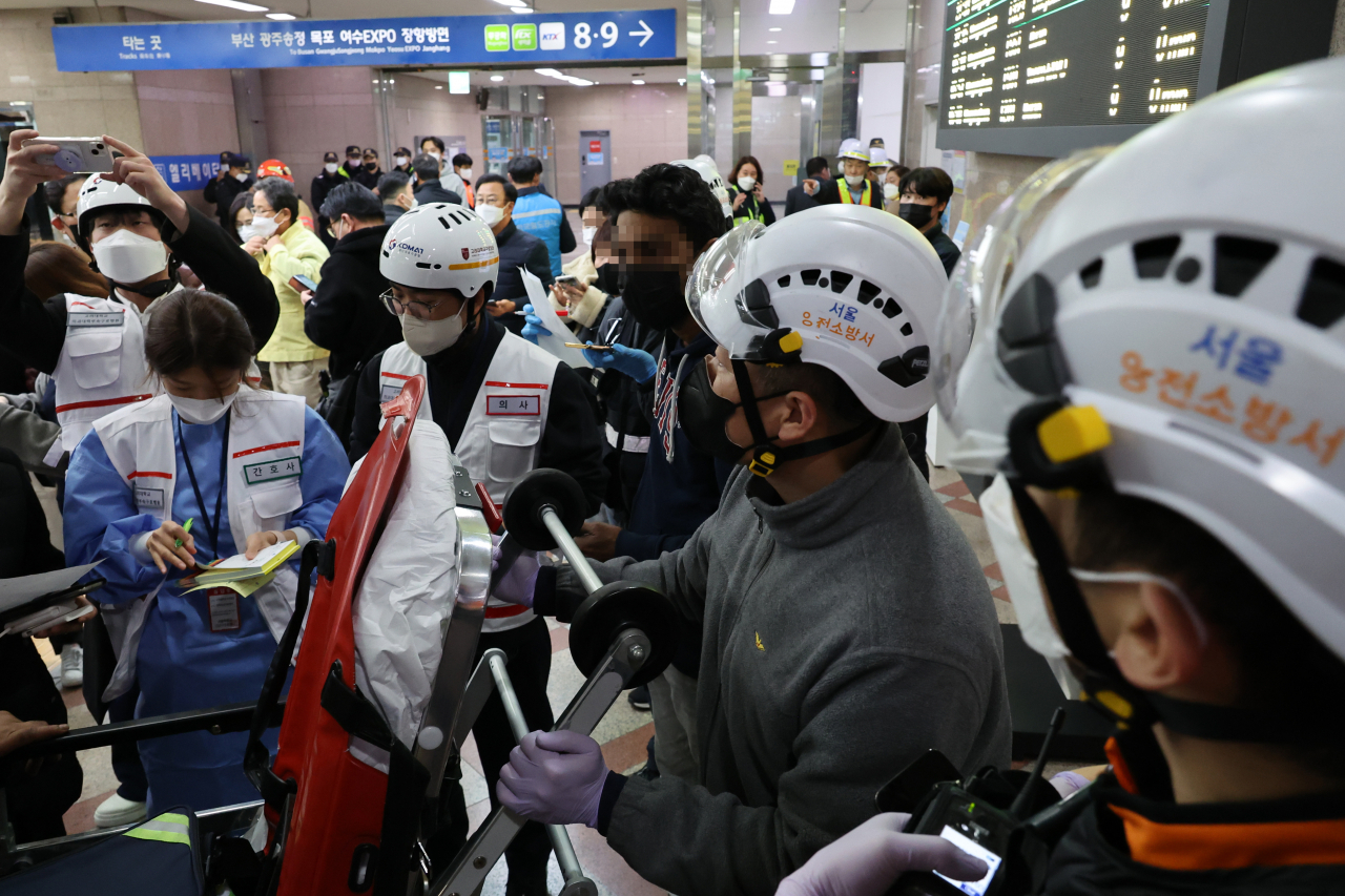 Rescue operators check lists of injuries at Yeongdeungpo Station in central Seoul after a train with 275 passengers aboard derailed while entering the station on Nov. 6, 2022. (Yonhap)
