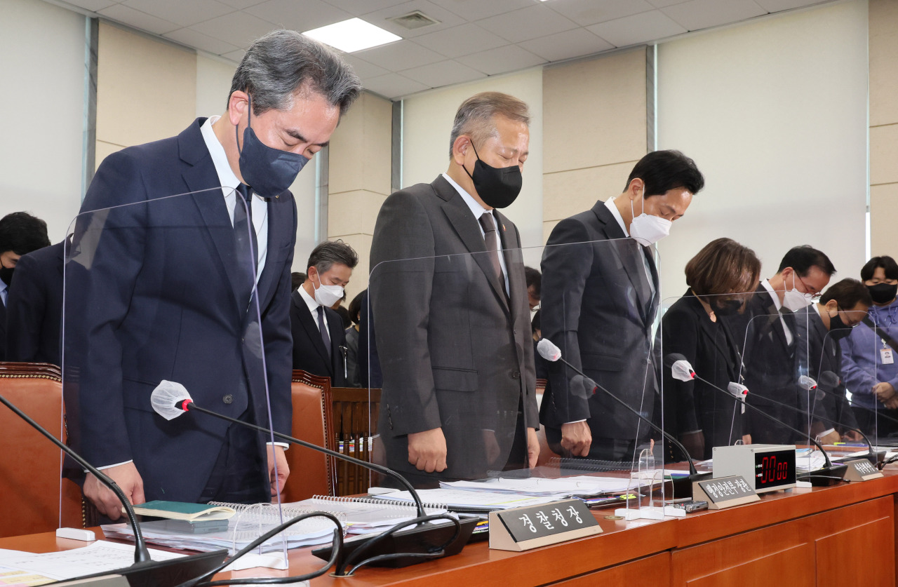 Officials and lawmakers close their eyes during a moment of silence for the deadly Halloween crowd surge during a National Assembly grilling on Monday. From left, the Korean National Police Agency’s Commissioner General Yoon Hee-keun; Minister of Interior and Safety Lee Sang-min; and Seoul Mayor Oh Se-hoon. (Yonhap)