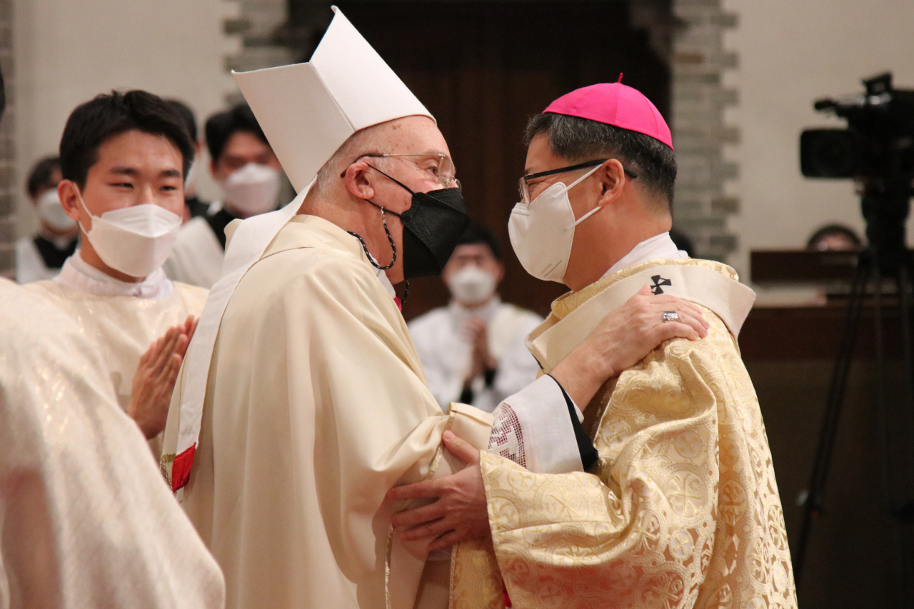 Archbishop of Seoul Peter Chung Soon-taick (right) receives the archiepiscopal pallium from Apostolic Nuncio to South Korea Alfred Xuereb during a mass at Myeongdong Cathedral in Seoul on Monday. (Catholic Archdiocese of Seoul)
