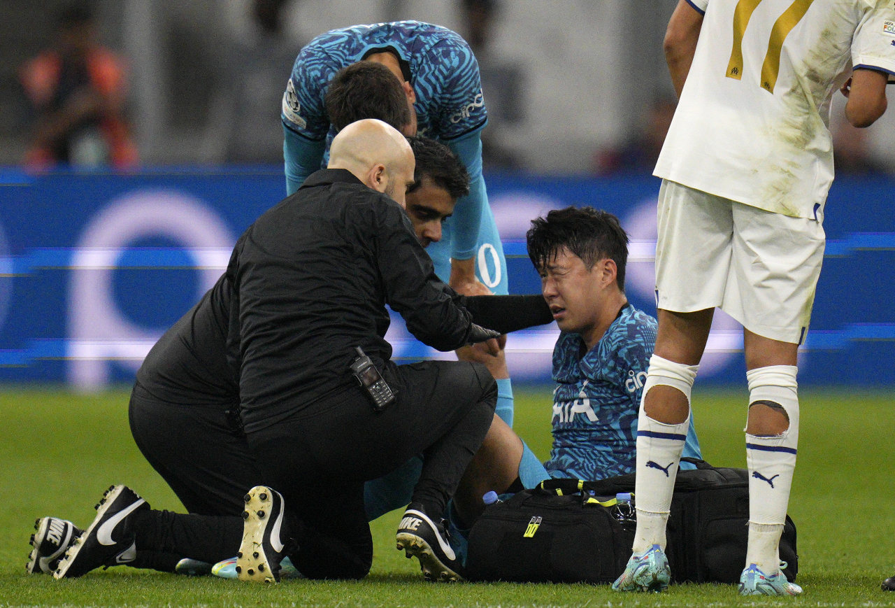 Son Heung-min of Tottenham Hotspur (second from right) receives treatment for a facial injury during the team's UEFA Champions League Group D match against Marseille at Stade de Marseille in Marseille, France, last Tuesday. (AP)