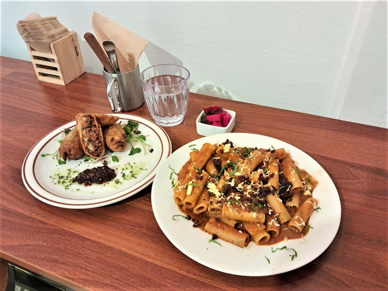 Kimchi arancini lumpia (left) and smoky Bolognese pasta (Lee Si-jin/The Korea Herald)