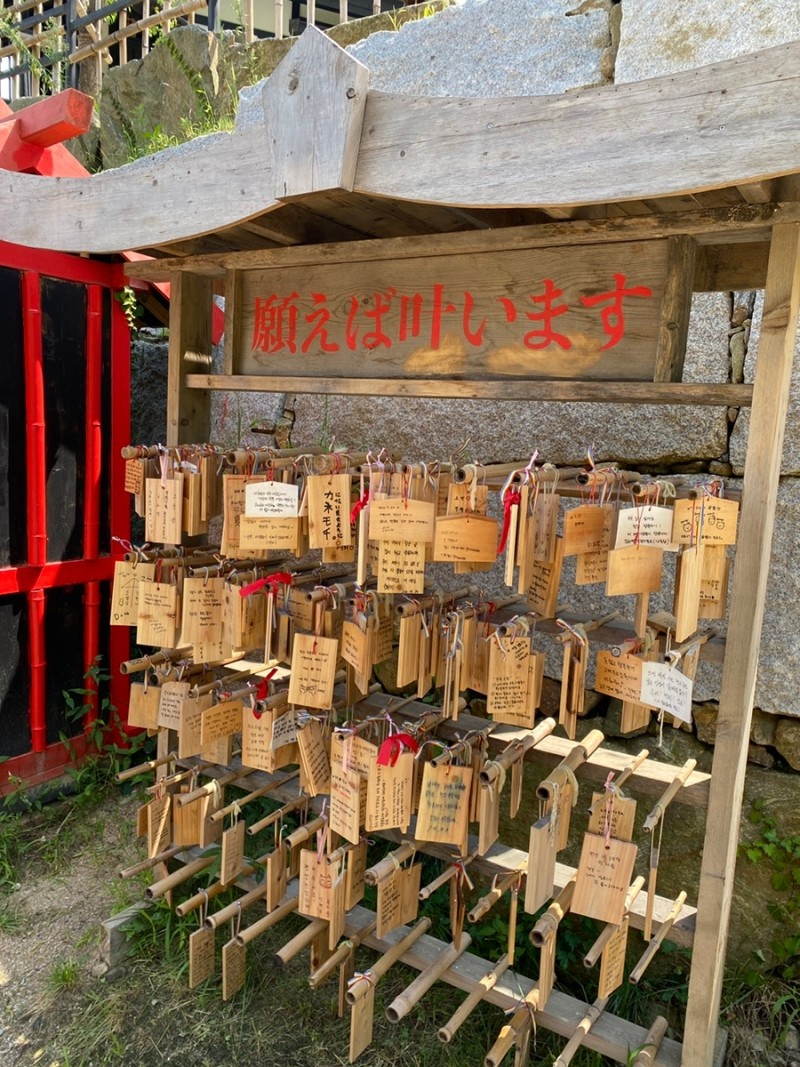 Paper strips or bamboo plaques on which guests wrote their wishes and prayers hang on wooden hooks of one of shinto shrines at Nijimori Studio. (Courtesy of Nijimori Studio)
