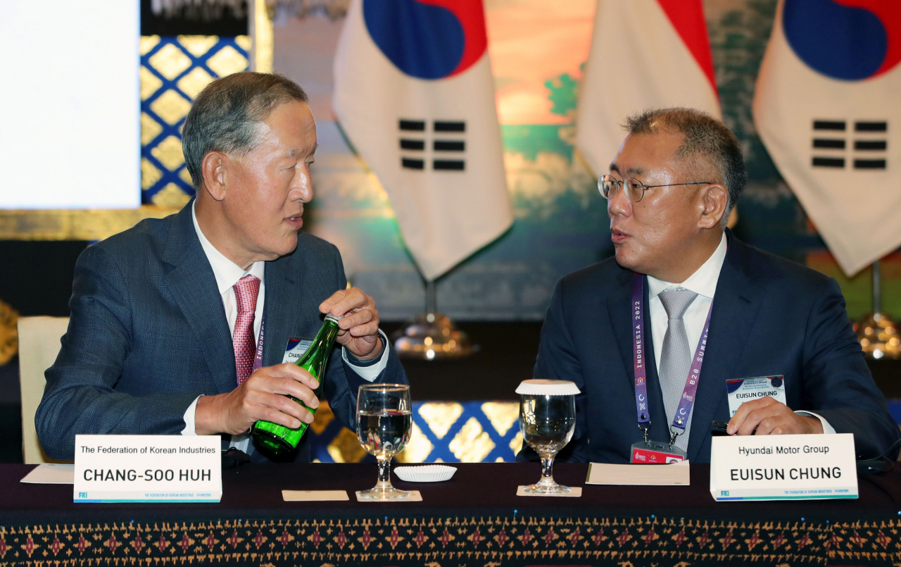 Huh Chang-soo (left), chairman of Federation of Korean Industries, and Hyundai Motor Group Executive Chair Chung Euisun talk during a Korea-Indonesia business roundtable event held on the sidelines of the G-20 summit in Bali, Indonesia, Monday. (Yonhap)