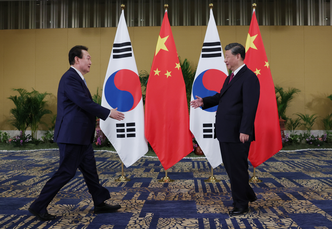 President Yoon Suk-yeol and Chinese President Xi Jinping shake hands at the Korea-China summit held at a hotel in Bali, Indonesia, on Tuesday (local time). (Yonhap)