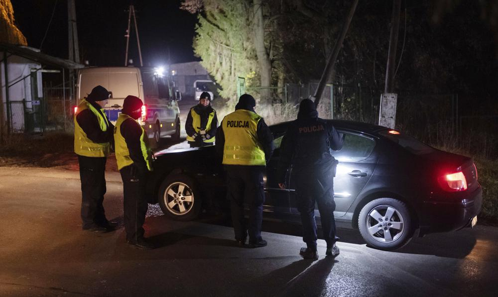 Police officers gather outside a grain depot in Przewodow, eastern Poland, on Tuesday, where the Polish Foreign Ministry said that a Russian-made missile fell and killed two people. The ministry said Foreign Minister Zbigniew Rau summoned the Russian ambassador and 