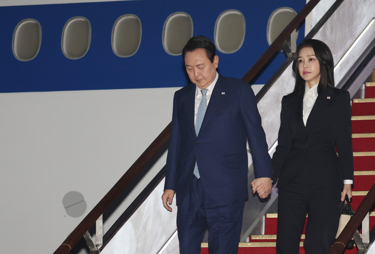 President Yoon Suk-yeol (left) and first lady Kim Kun-hee arrive at Seoul Air Base in Seongnam, Gyeonggi Province, early Wednesday, returning from a six-day trip to Southeast Asia. (Yonhap)