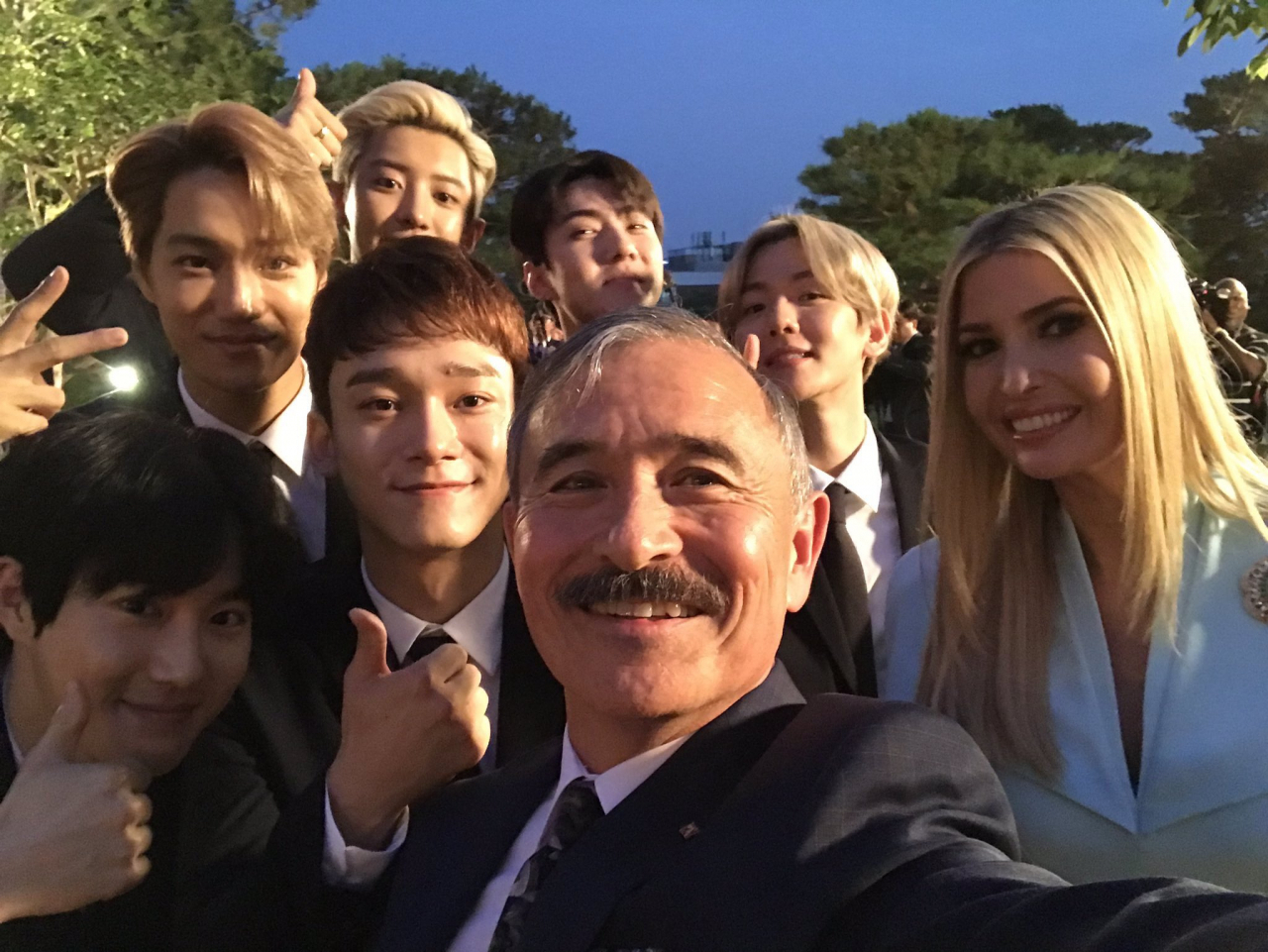 K-pop group Exo poses with Harry Harris, former US ambassador to South Korea, and Ivanka Trump, former White House adviser, during a cocktail reception at the Blue House in 2019. (Screenshot captured from Twitter)