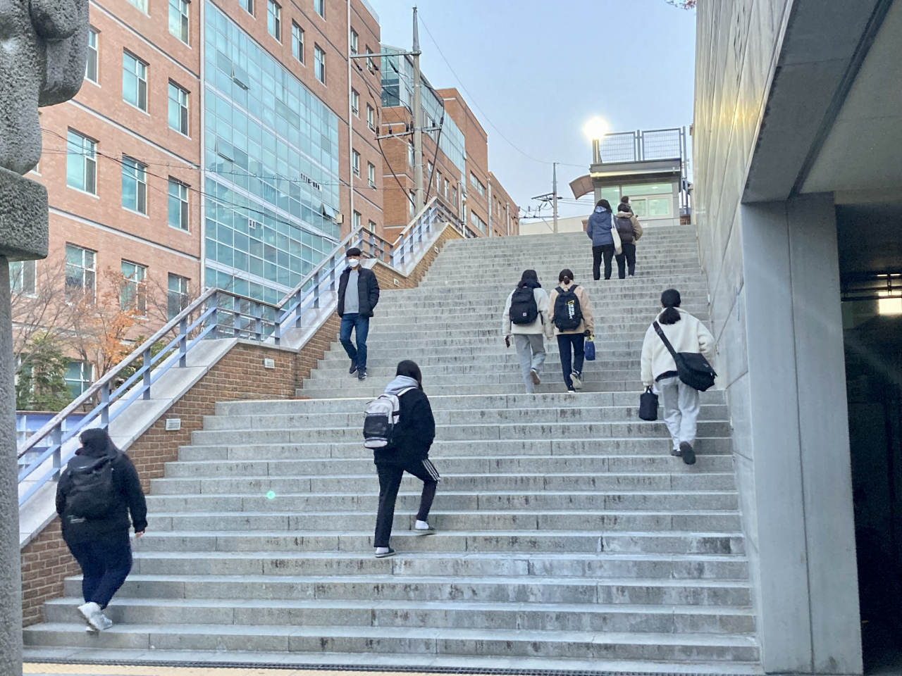 Students go up the stairs in front of Myoungji High School as they attend the Suneung exam, Thursday. (Im Eun-byel / The Korea Herald)