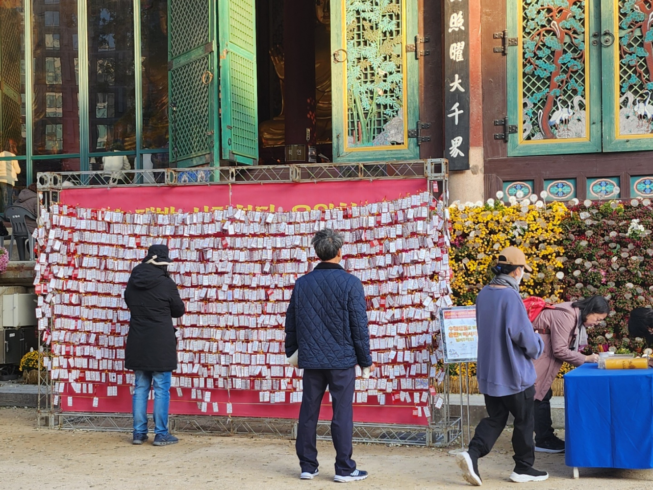 Visitors write down their hopes on the wish card, praying for their children taking Suneung, Thursday, at Jogyesa, a sacred temple in Jongno-gu, Seoul. (Lee Jung-youn / The Korea Herald)