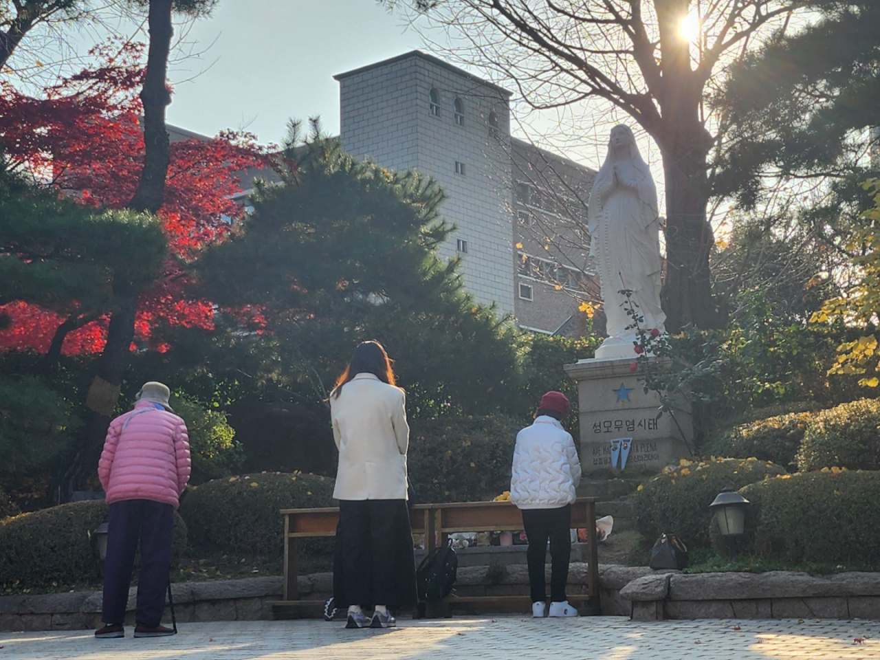 Visitors at Myeongdong Cathedral, Jung-gu, Seoul, pray in front of the statue of Virgin Maria, wishing luck for their children taking Suneung, Thursday. (Lee Jung-youn / The Korea Herald)