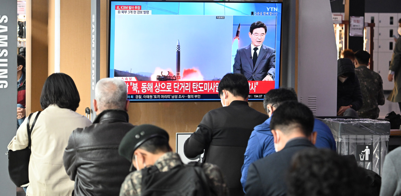 Passersby watch a news report on North Korean missile launches early Thursday at Yongsan Station in Seoul. (Im Se-jun/The Korea Herald)