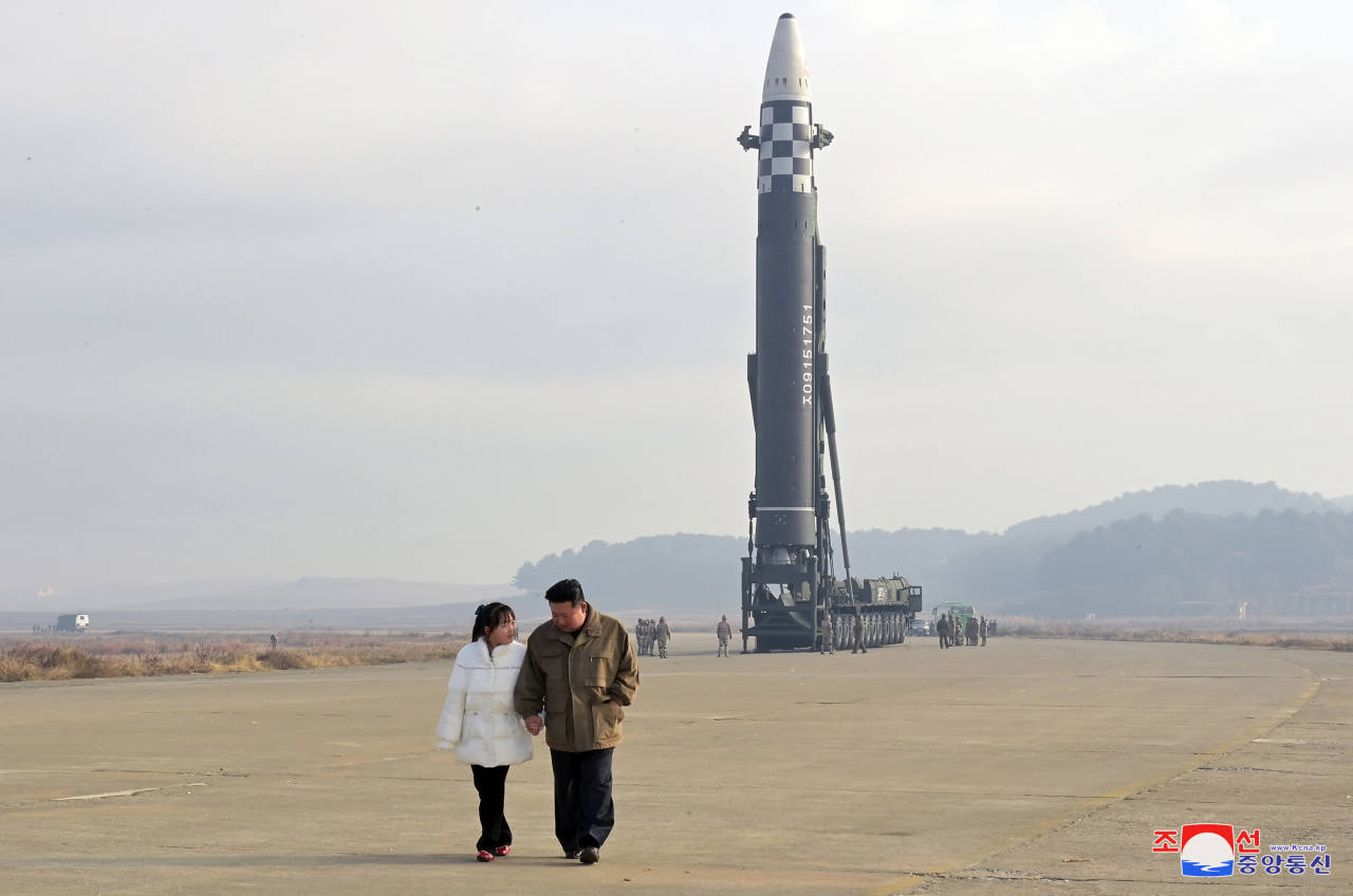 North Korean leader Kim Jong Un and his daughter walk away from an intercontinental ballistic missile in this undated photo released on Saturday by KCNA. (Yonhap)