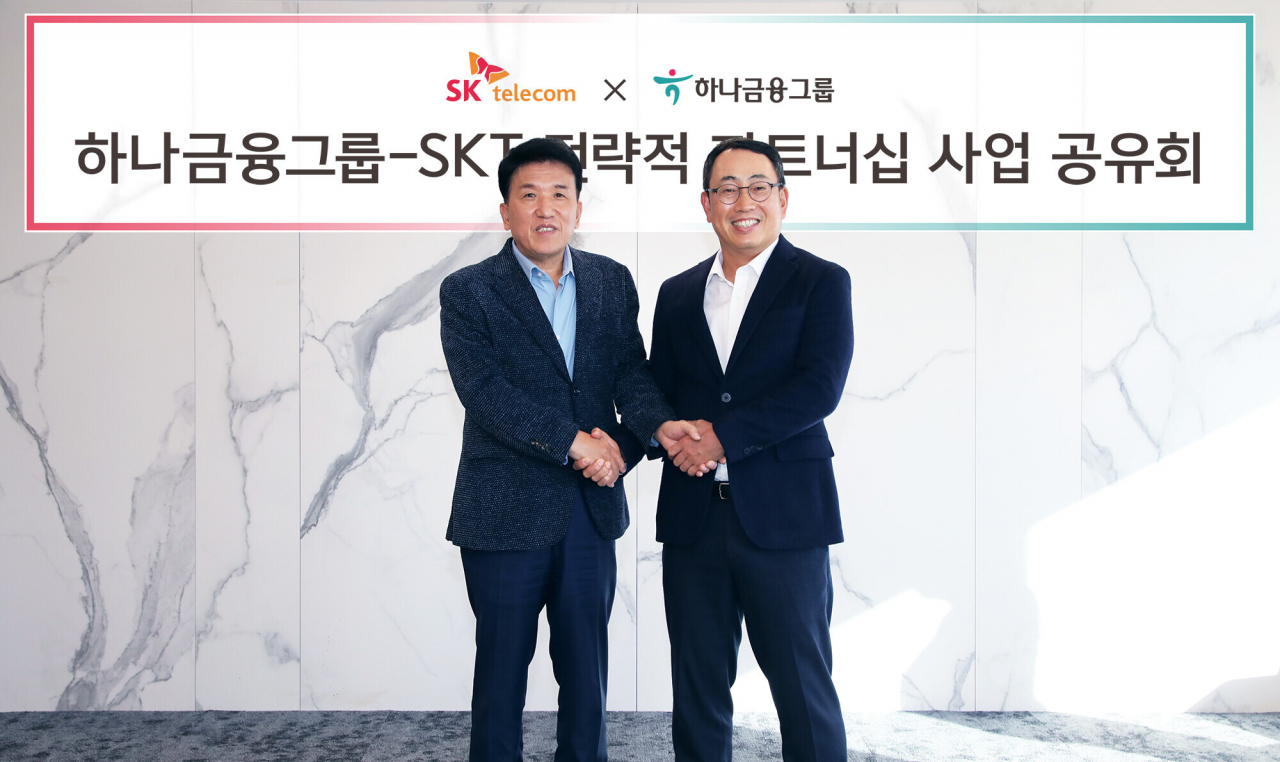 Hana Financial Group Chairman Ham Young-joo (left) and SK Telecom CEO Ryu Young-sang pose for a photo after deciding to work together on digitalization. (Hana Financial Group)