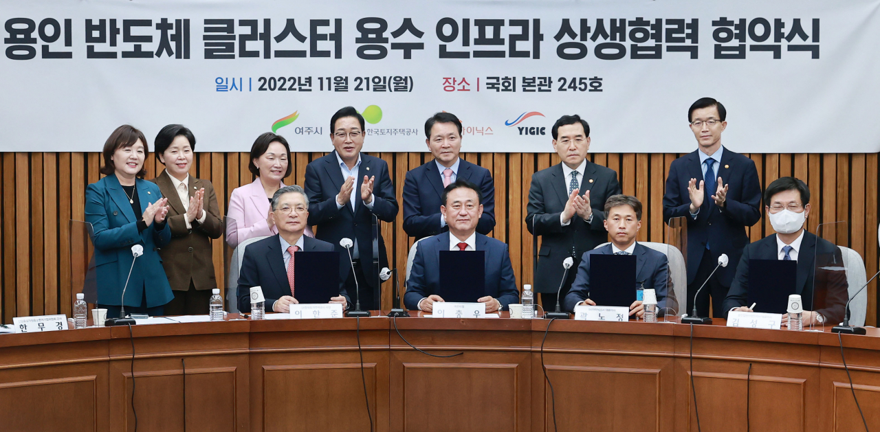 SK hynix co-CEO Kwak Noh-jung (third from left, front row), Yeoju Mayor Lee Choong-woo (second from left, front row) and Industry Minister Lee Chang-yang (second from right, back row) and other parties concerned pose for a photo at the MOU signing ceremony between SK hynix and Yeoju at the National Assembly in Seoul on Monday. (Yonhap)