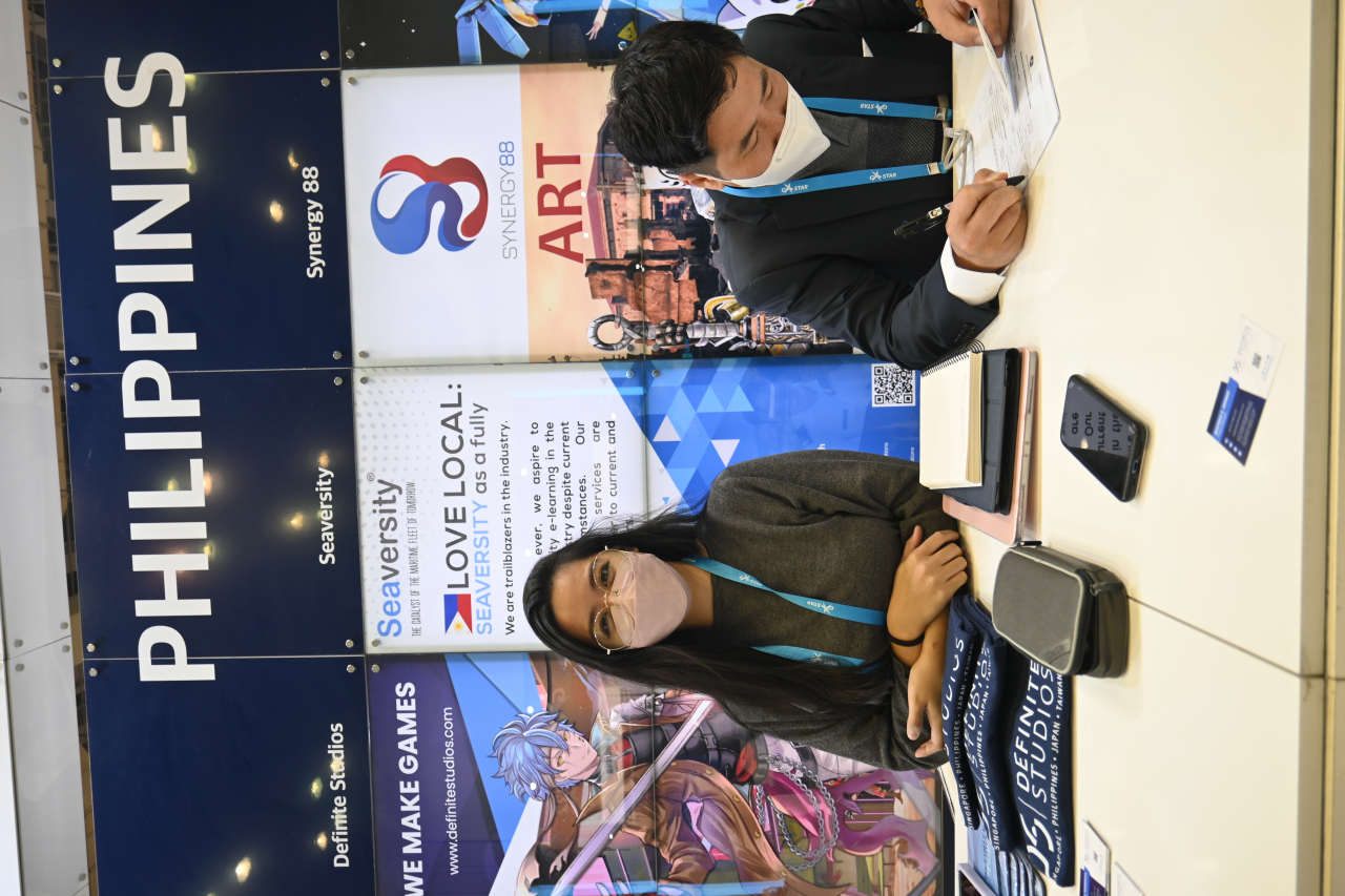 Beatrice s aranas, the project manager of definite studio in Philippines introducing her company’s business model and services offered to a visitor at the ASEAN game pavilion at G-star in Bexco exhibition center, Busan on Thursday.(Sanjay Kumar/The Korea Herald)