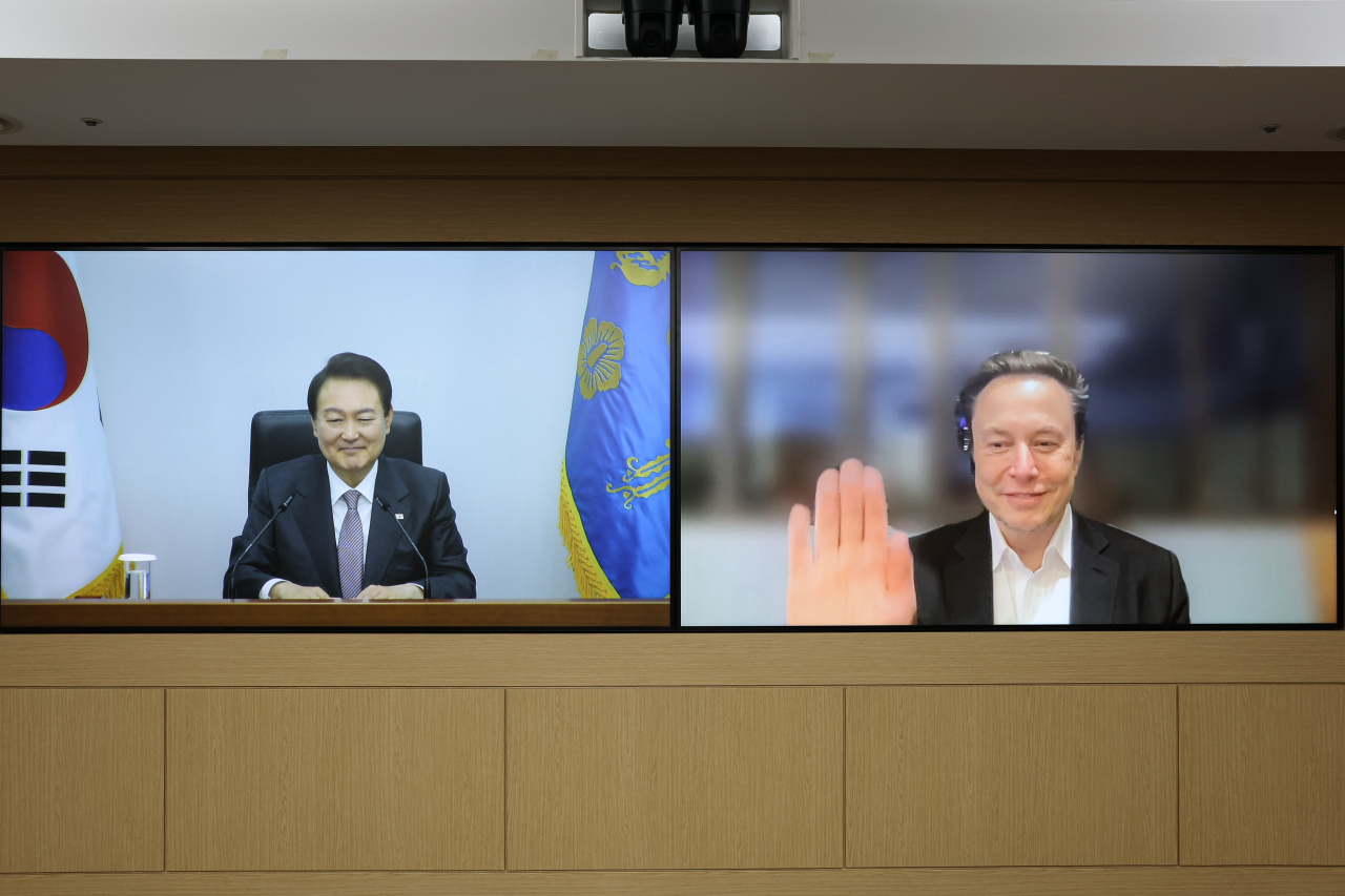 President Yoon Suk-yeol (left) greets Tesla CEO Elon Musk by videoconference at the presidential office building in Yongsan, Seoul, Wednesday. (Yonhap)