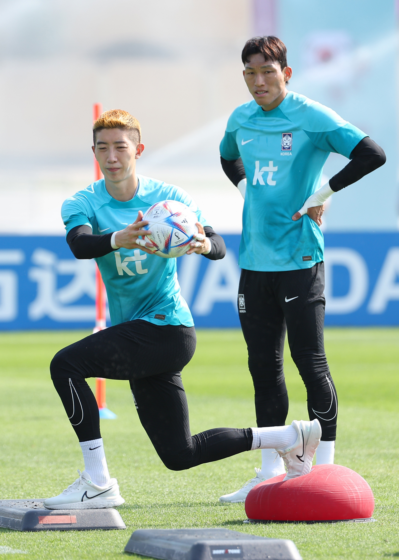 South Korean goalkeepers Kim Seung-gyu (right) and Jo Hyeon-woo warm up during the national team's training at the Al Egla Training Facility in Doha, on Saturday. (Yonhap)