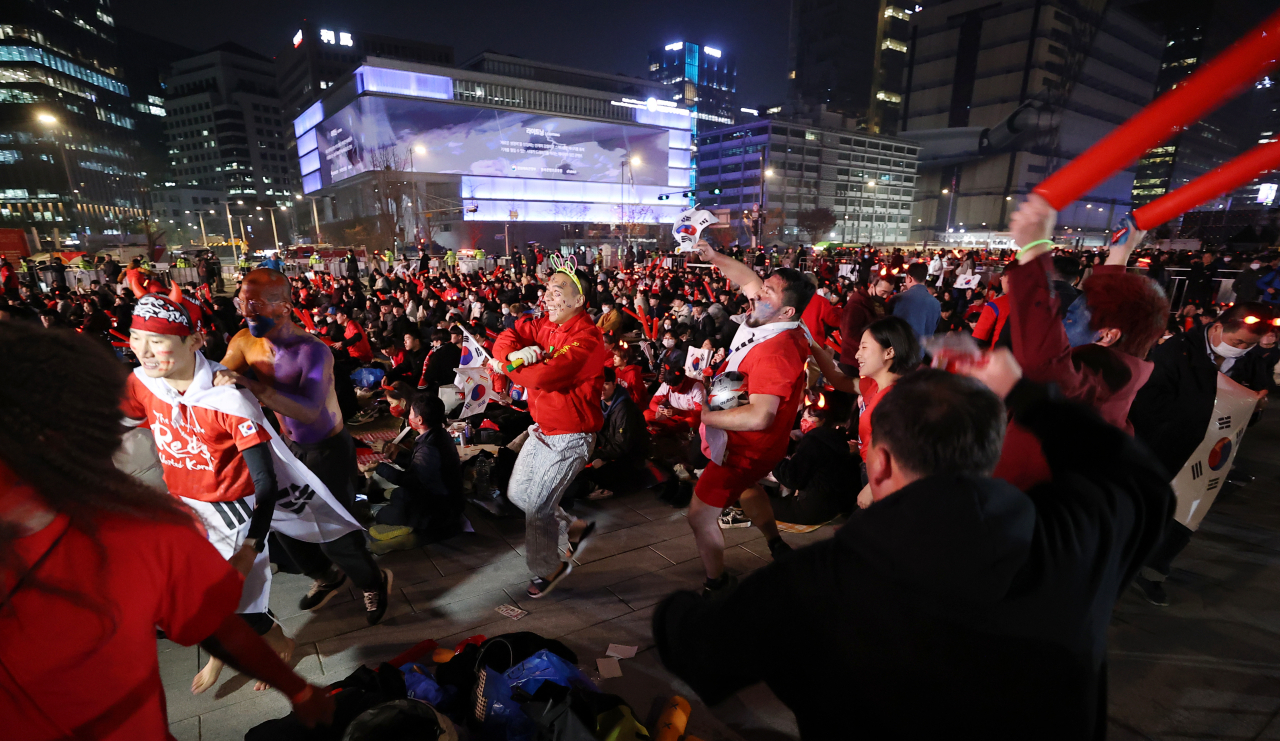 Fans seen dancing at public screening event Thursday at Gwanghwamun Square, central Seoul, for South Korean national soccer team's match against Uruguay. (Yonhap)