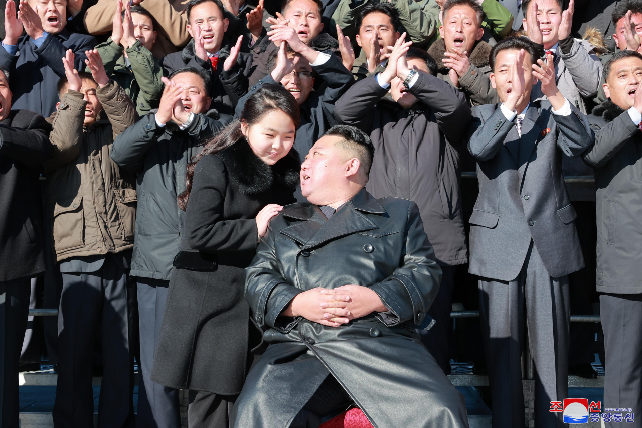 North Korean leader Kim Jong-un (front, R) poses with his daughter, presumed to be his second child, Ju-ae, during a photo session with officials involved in this month's intercontinental ballistic missile launch, in this photo provided by the Korean Central News Agency on Nov. 27, 2022. (Yonhap)