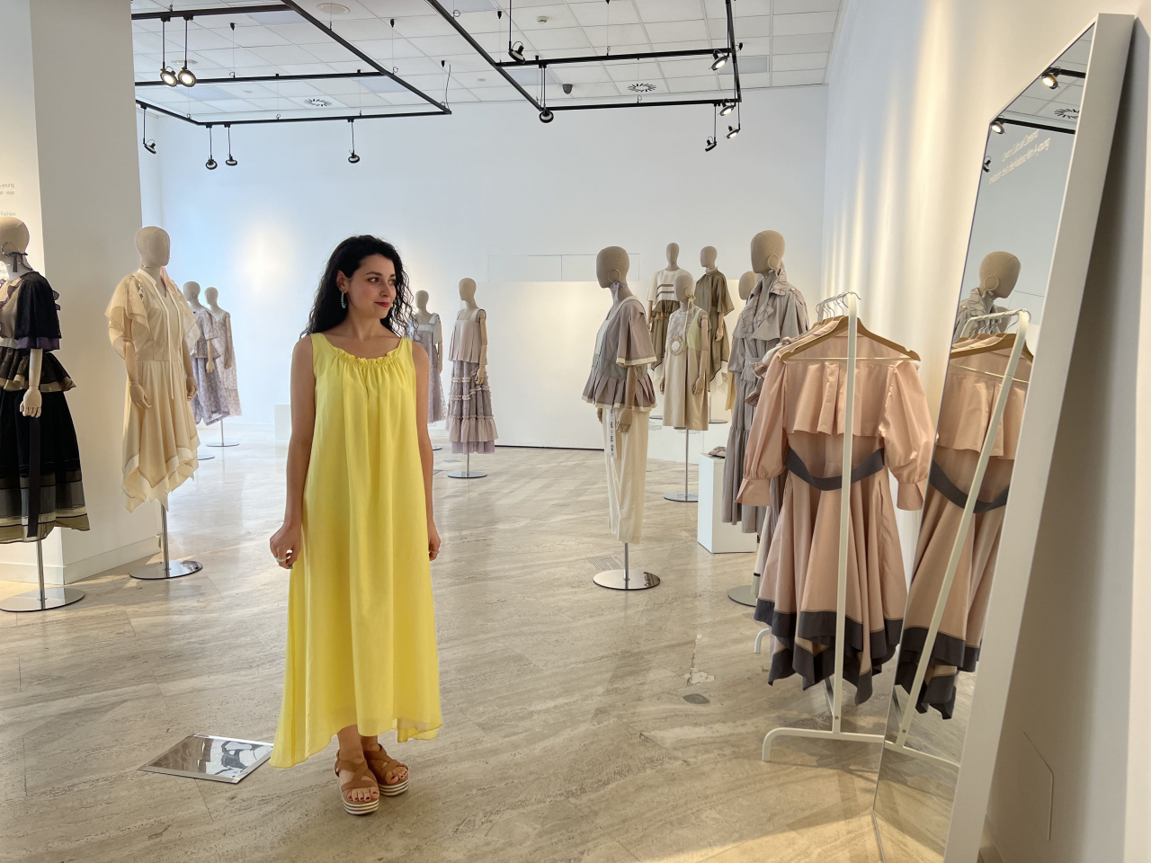 A Spanish visitor tries on a dress of Korean fashion designer Kim A-young in an exhibition space at the Korean Cultural Center of Madrid in June. (The Korean Cultural Center of Madrid)