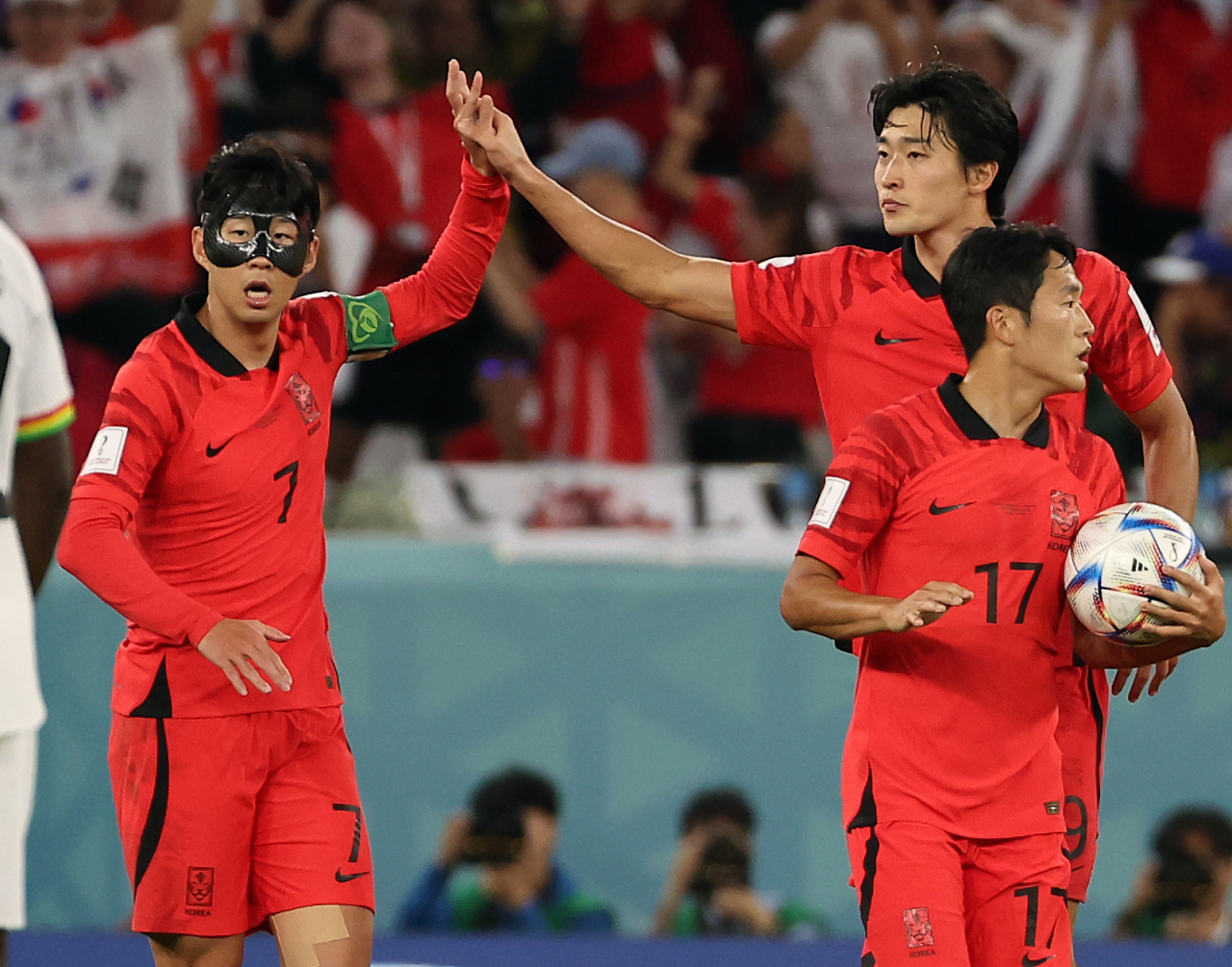 South Korean captain Son Heung-min (left) high-fives Cho Gue-sung during their match against Ghana at Education City Stadium in Al Rayyan, Qatar. (Yonhap)
