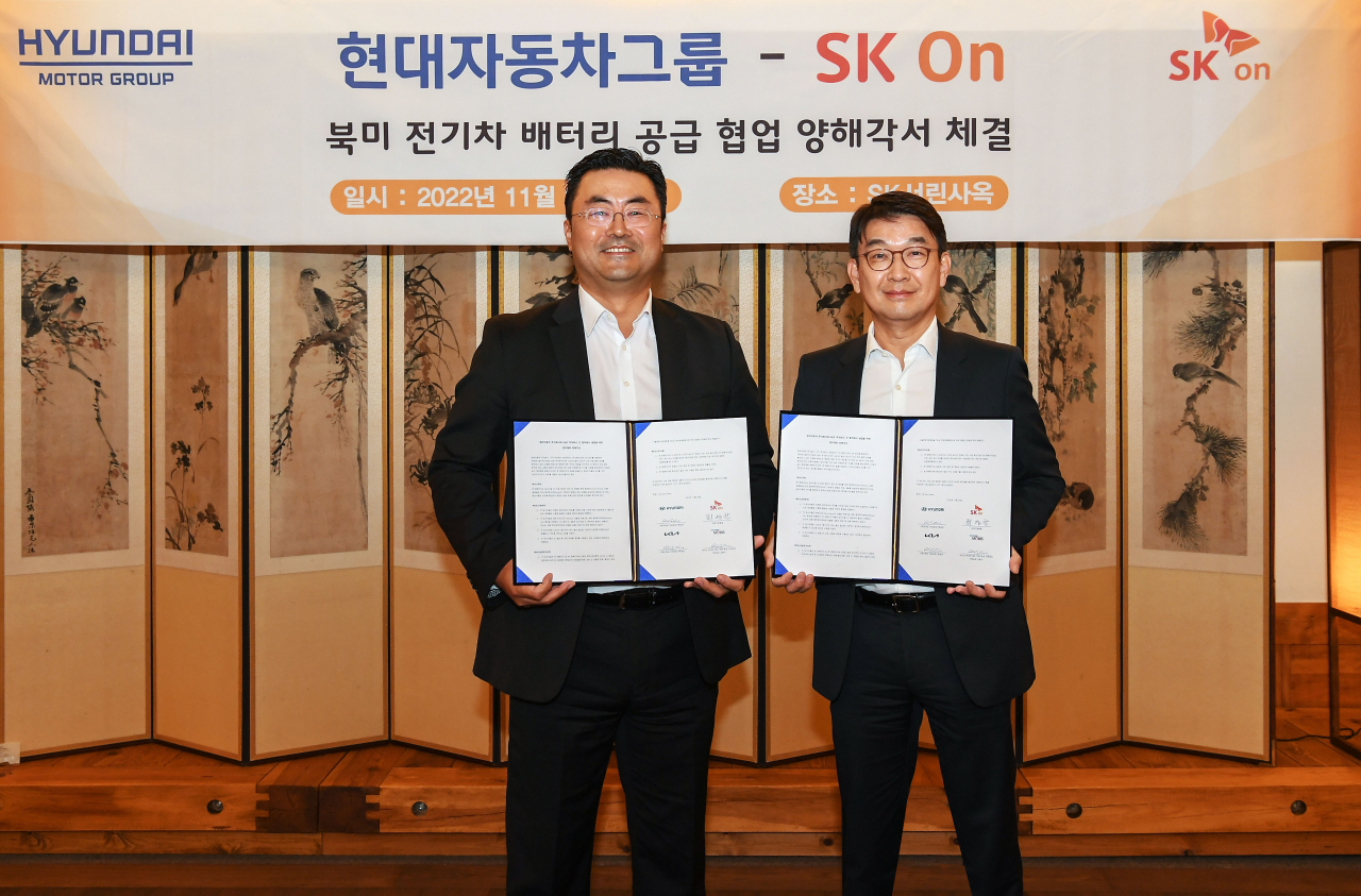 Kim Heung-soo (left), Hyundai Motor Group's executive vice president, and Choi Kyung-chang, leader of SK On's management team, hold their partnership signing in Seoul on Tuesday. (Hyundai Motor Group)