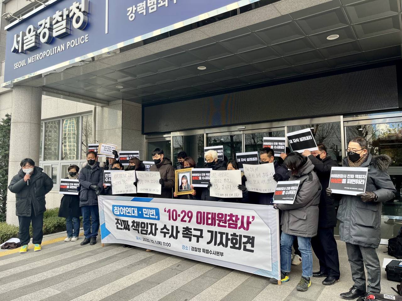 The bereaved families of the victims of the crowd crush in Seoul’s Itaewon last month speak outside the Seoul metropolitan police office on Thursday. The man speaking with a microphone (farthest left) is Suh Chae-wan, one of the lawyers at Minbyun working with the families. (Kim Arin/The Korea Herald)