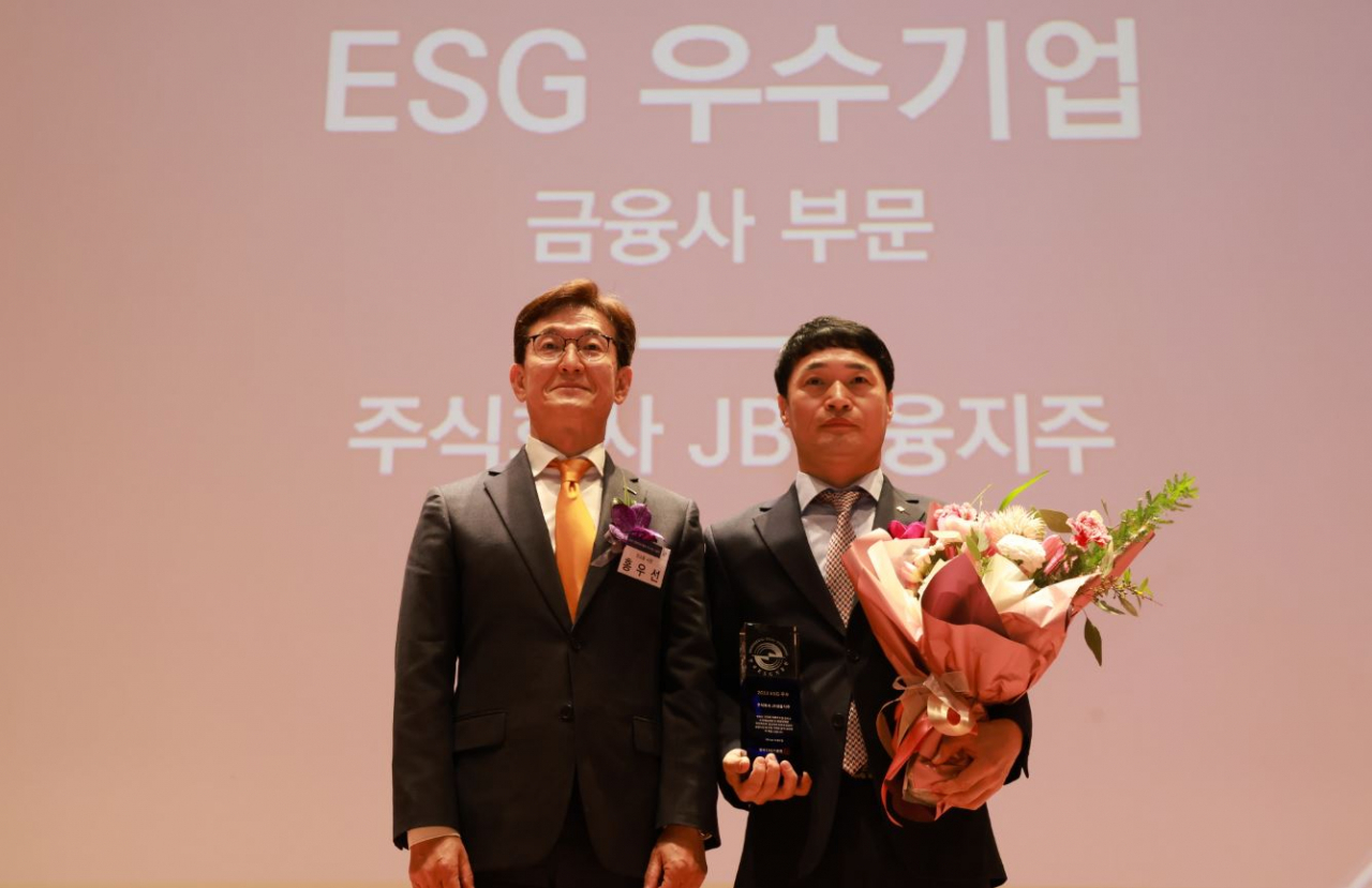 JB Financial Group Managing Director Kim Seon-ho (right) poses for a photo with Koscom CEO Hong Woo-sun after receiving the ESG Excellent Company Award at the Korea Institute of Corporate Governance and Sustainability awards ceremony held at the Korea Exchange in Yeouido, Seoul, on Friday. (JB Financial Group)