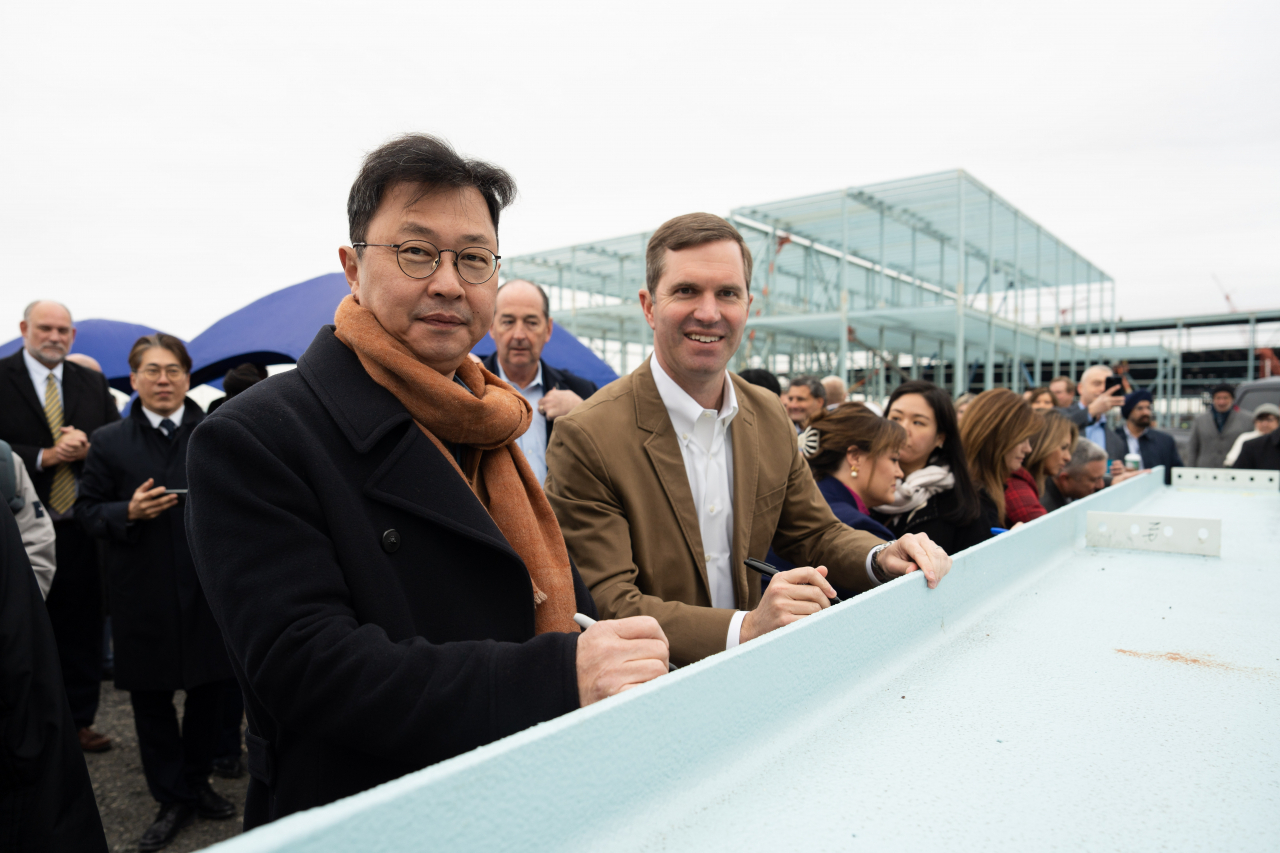 SK Group Executive Vice Chairman Chey Jae-won (left) and Kentucky Gov. Andy Beshear pose for a photo during a beam signing event at the groundbreaking ceremony of BlueOval SK Battery Park in Glendale, Kentucky, Friday. (SK On)